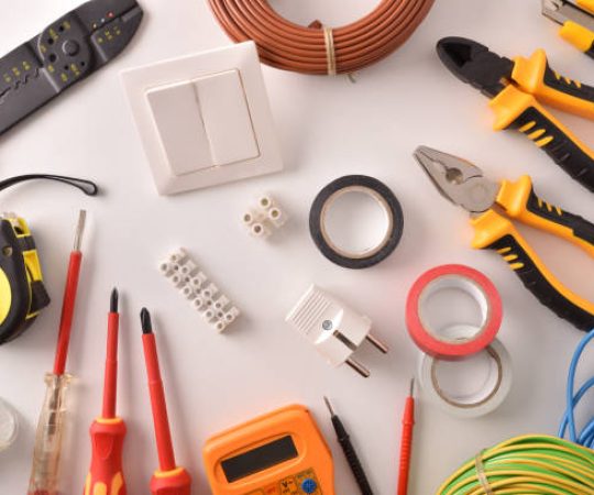 Tools and electrical material on a white table general view Horizontal composition. Top view.